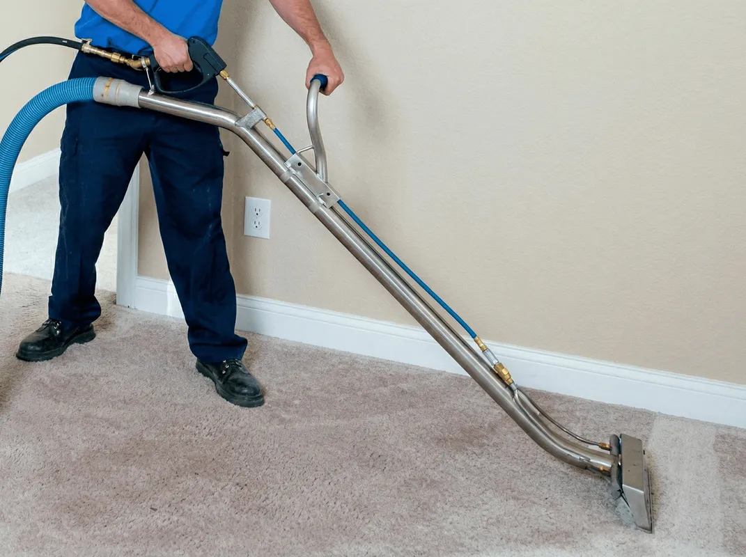 Professional operating a liquid removal machine on a carpeted floor in Austin, TX